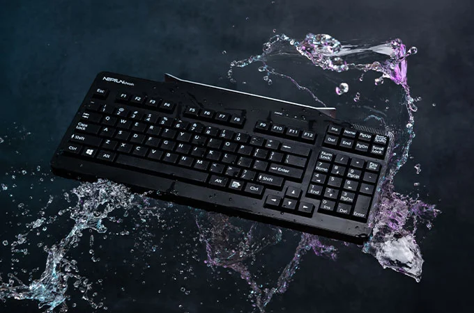 Teclado robusto y resistente al agua que se rodea de salpicaduras y muestra su resistencia a los l&iacute;quidos.