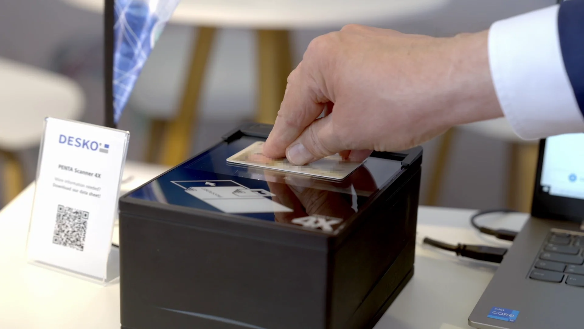 La mano coloca un documento de identidad en un esc&aacute;ner de documentos compacto para verificar digitalmente la identidad y la tarjeta.