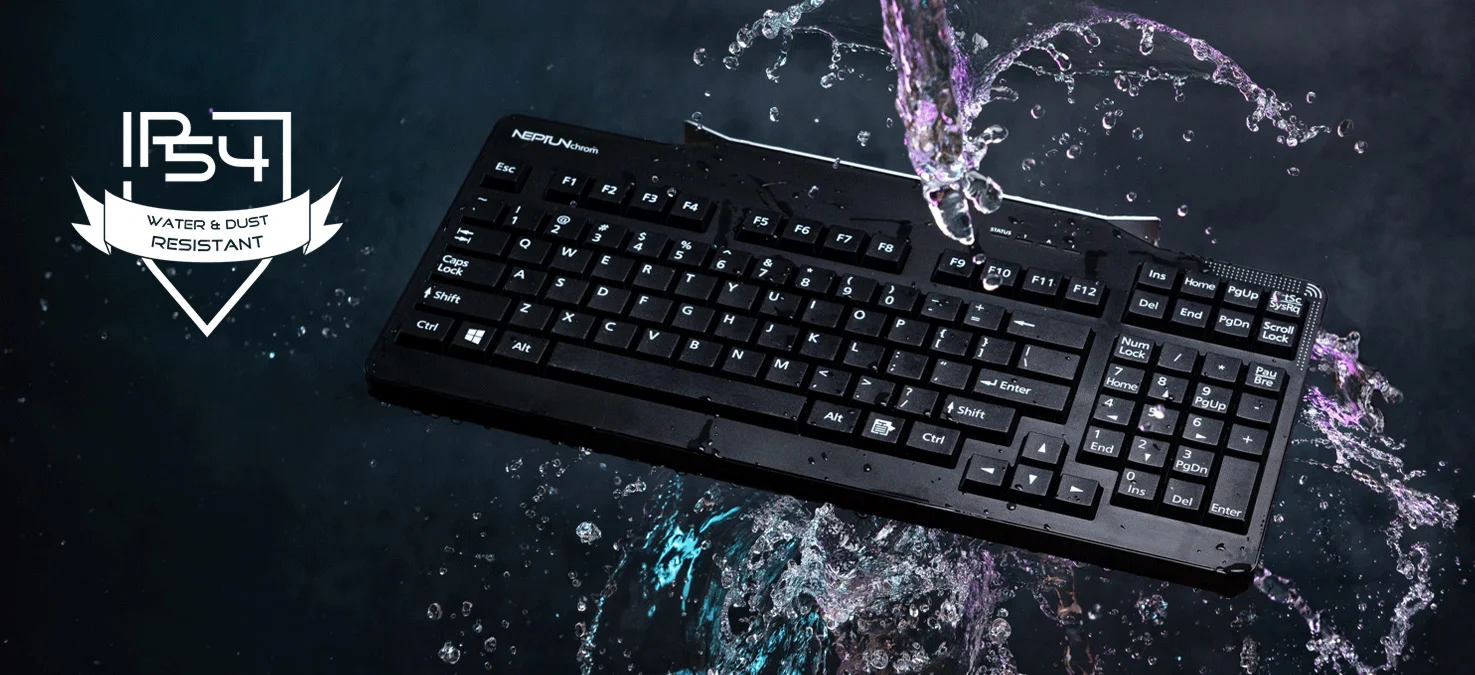 El teclado de ordenador negro est&aacute; rodeado de salpicaduras de agua, sobre un fondo oscuro con un grado de protecci&oacute;n IP54 contra el agua y el polvo.