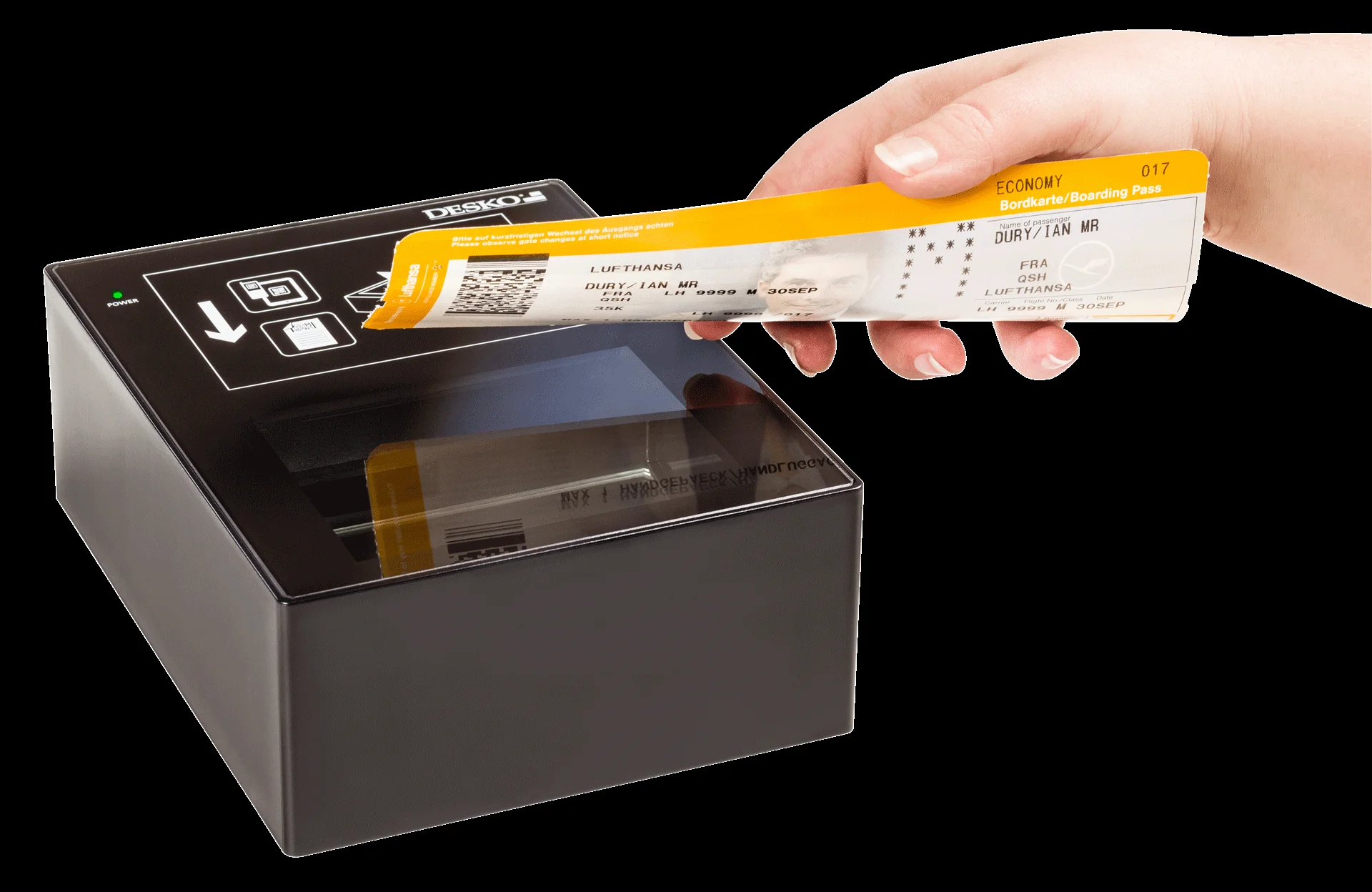 Mano sosteniendo tarjeta de embarque amarilla sobre un esc&aacute;ner de documentos DESKO compacto con superficie de cristal.