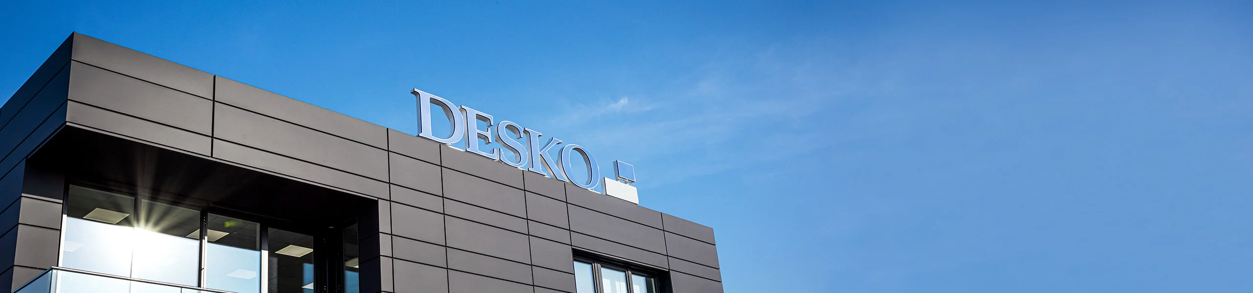 现代化的 DESKO 公司总部，在蓝天的映衬下，外墙上的标志十分醒目。