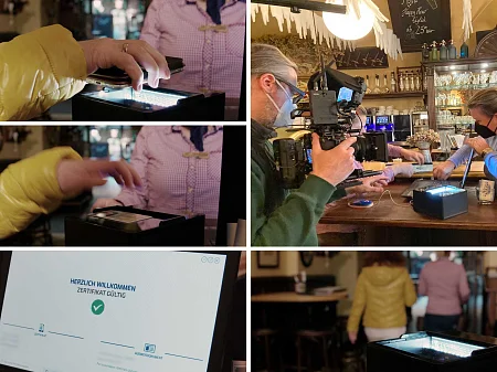 Equipo de cine documentos de identidad control en un bar: la persona escanea el documento, la pantalla muestra el certificado válido, los clientes atienden en el mostrador.