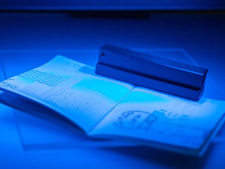 Al abrir el pasaporte bajo el escáner de luz ultravioleta azul, se visualizan los elementos de seguridad y los elementos impresos.