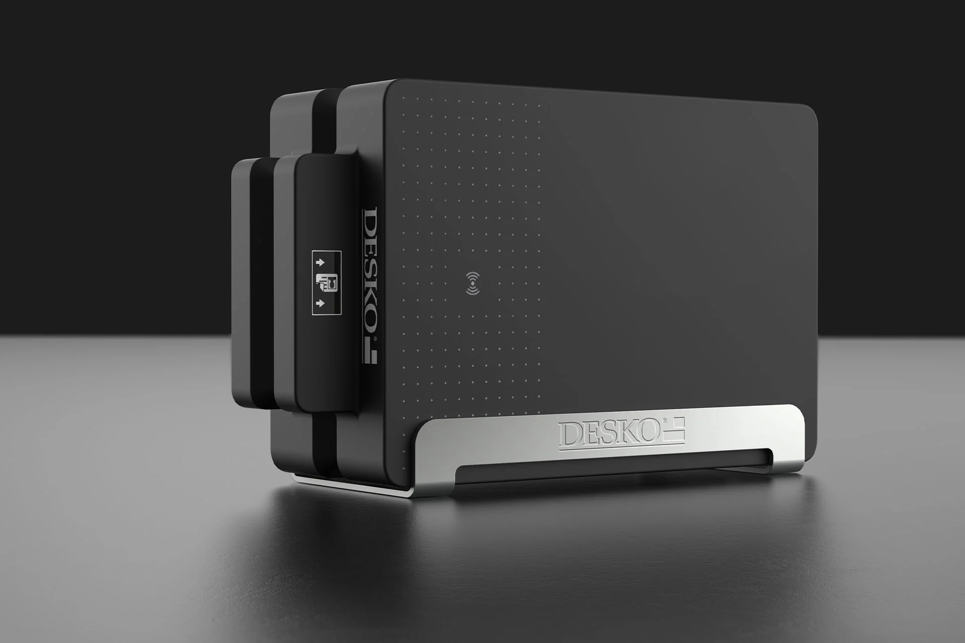 Dispositivo DESKO negro de dise&ntilde;o moderno sobre fondo oscuro, forma compacta con base met&aacute;lica y s&iacute;mbolo NFC.