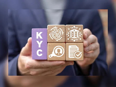 Manos sosteniendo bloques de madera con símbolos KYC que representan la verificación de la identidad, el cumplimiento y la verificación segura de los clientes.