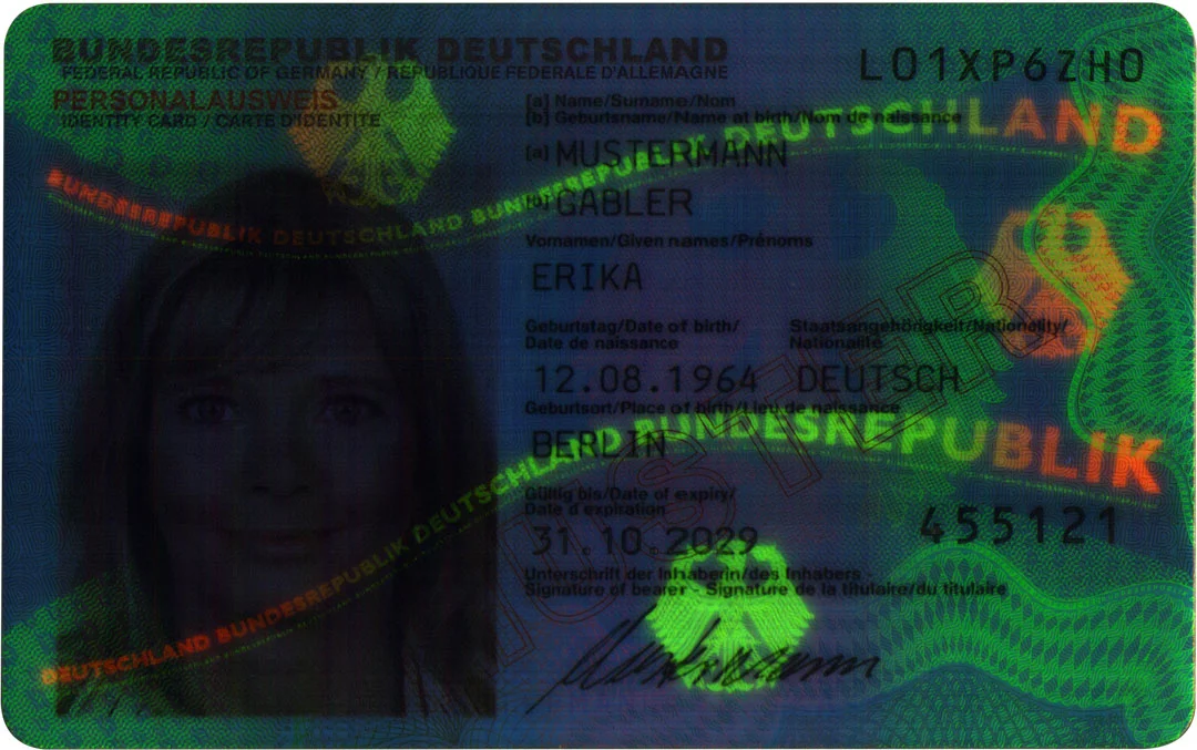 Imagen UV de un documento de identidad alem&aacute;n con motivos de seguridad fluorescentes, letras y retrato oculto.